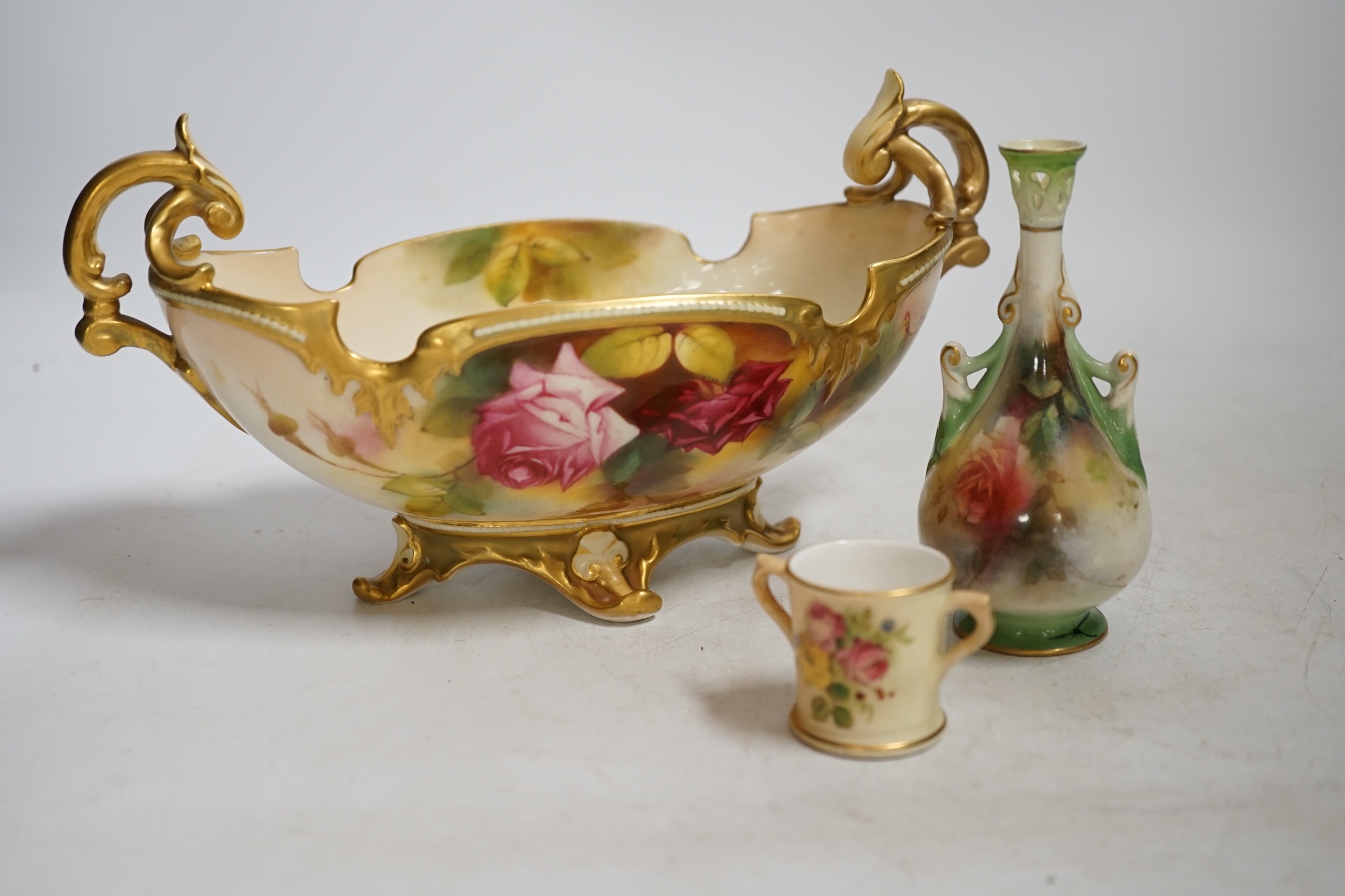 A Royal Worcester floral painted, twin handled dish, painted by Ethel Spilsbury, together with a miniature Worcester blush mug and a Hadley Worcester vase, dish 23.5cm wide. Condition - poor-fair